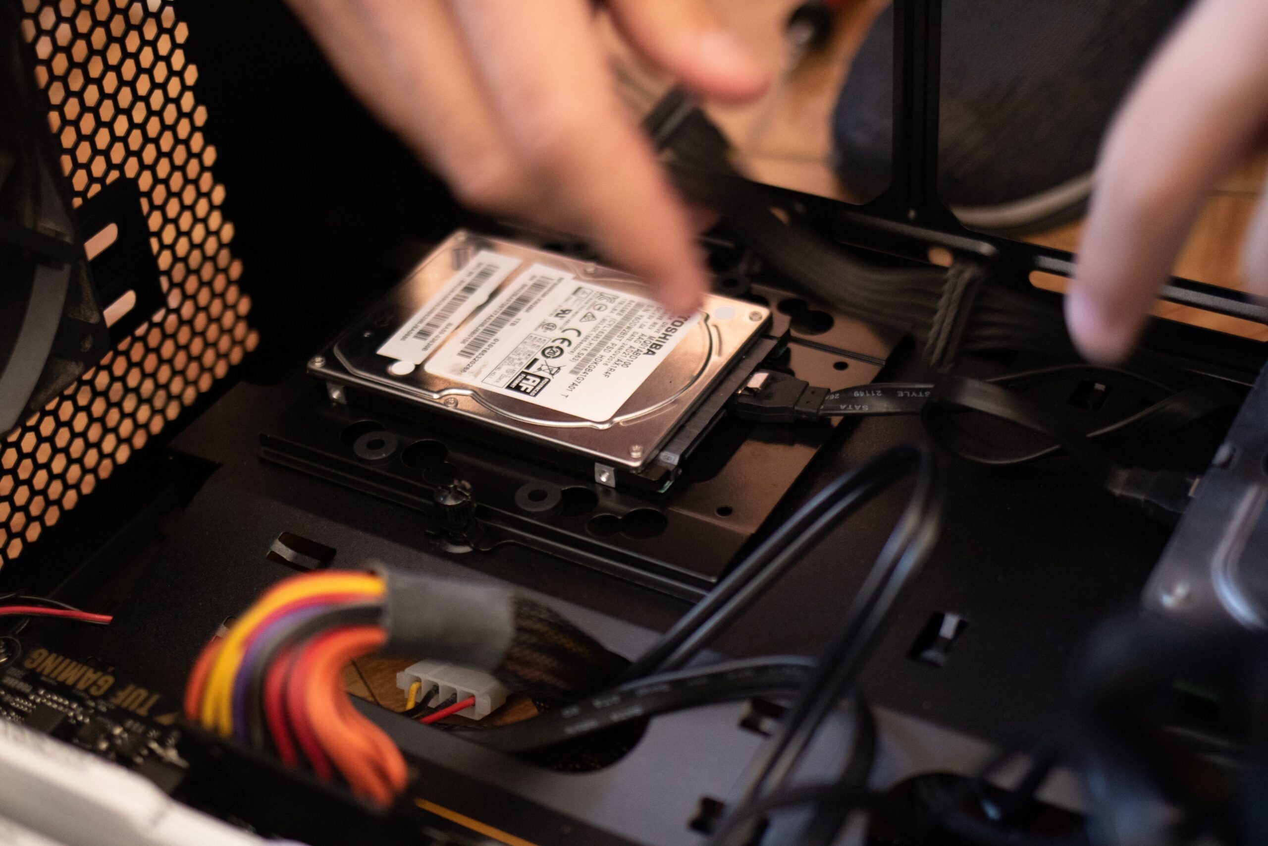 A computer hard drive being replaced in a case